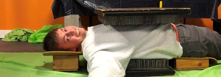 person on a bed of nails on floor