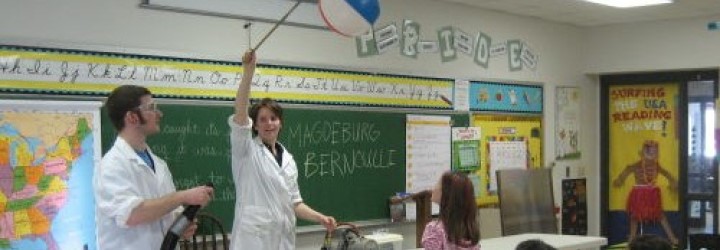 person teaching science to classroom using beachball