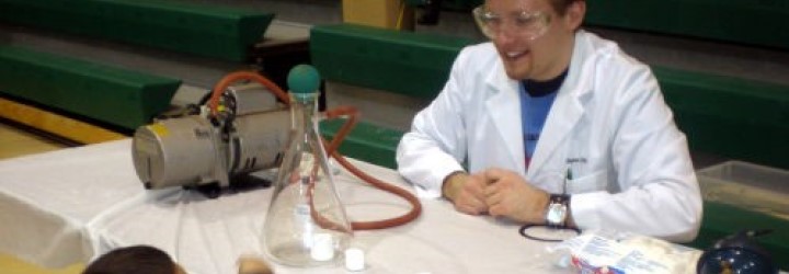 person teaching child with vacuum chamber and marshmallows